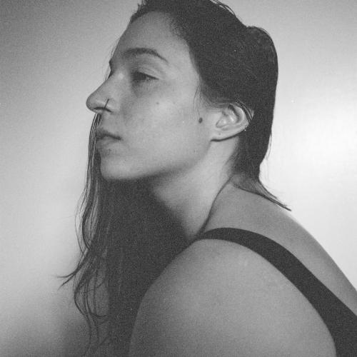 a black and white photo of casey in profile. she had dark hair, a nose ring, and a black tank top