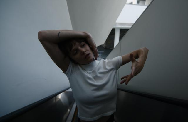 image of women with exaggerated arms in a white shirt in front of a white backdrop