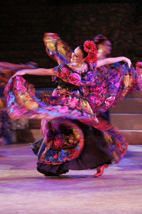 Folklore dancer with a big colorful dress swinging her arms and skirt