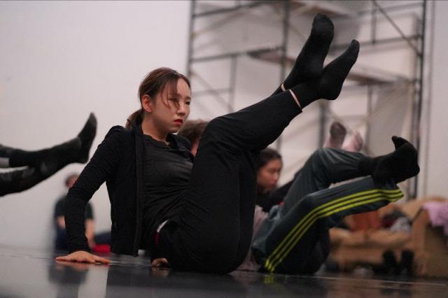 dancer sitting on the floor with legs crossed and elevated
