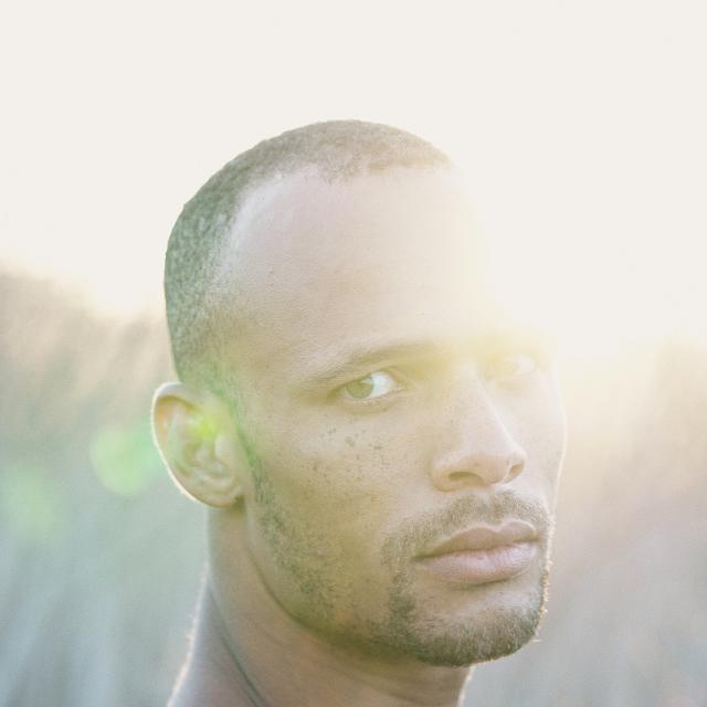 Mike Tyus looking at the camera with a ray of sunshine glare