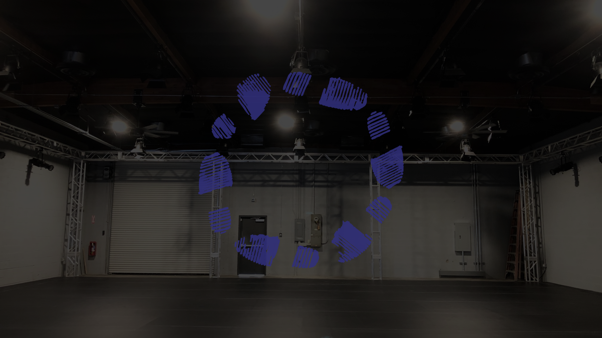 an image of the warehouse space overlaid with the stomping ground logo in blue