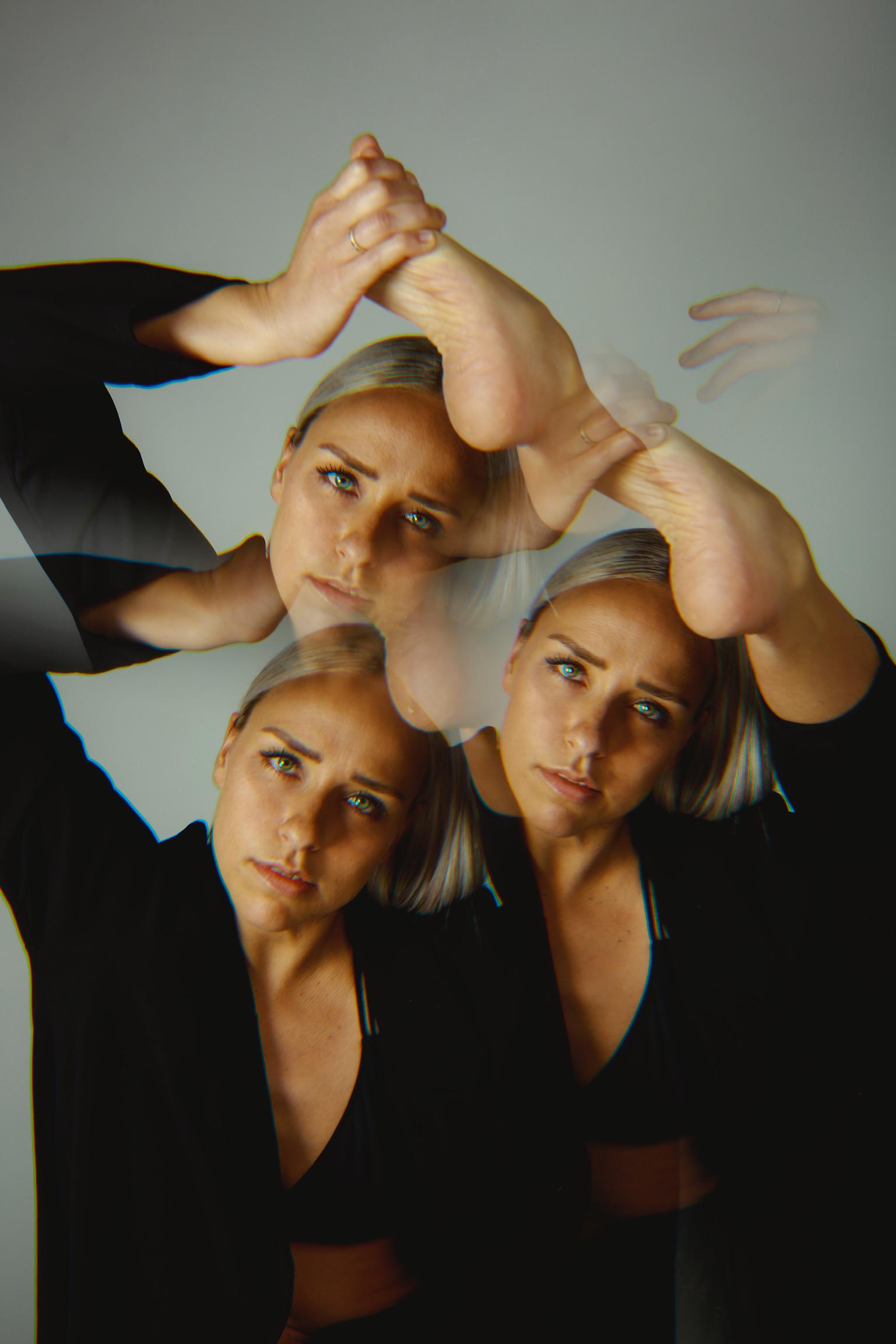 a kaleidoscope edited image of a dancer with blonde hair and a black outfit holding their foot above their head 